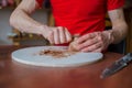 Close up view: potter shaping dry clay cup with special tool in pottery workshop