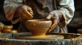 Close-up view of a pottery artist carefully shaping the stem of a goblet on a spinning wh