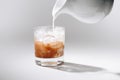 close up view of pouring milk into glass of iced coffee process Royalty Free Stock Photo