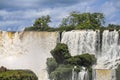 Close-up view of powerful cascading waterfalls and lush green vegetation and blue sky, Iguazu Falls, Argentina