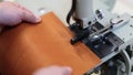 Close up view of a process of making leather craftwork. Worker using skiving machine