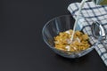 Close up view of process of pouring milk into glass bowl with cornflakes. Healthy eating concept. Healthy food background Royalty Free Stock Photo
