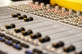 Close-up View of Professional Audio Mixing Console with Focus on Faders and Buttons in Recording Studio