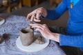 Close up view - professional male potter working in workshop, studio Royalty Free Stock Photo