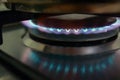 Close-up view on propane butane fuel LPG or petroleum gas kitchen stove hob with blue flame and metal cooking pot