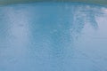 Close-up view of raindrops falling into the water of a children\'s pool in the backyard of a house Royalty Free Stock Photo