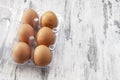 Close-up view of raw chicken eggs in egg box on white wooden background Royalty Free Stock Photo