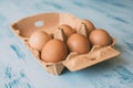 Close up view of raw chicken eggs in egg box on white wooden background Royalty Free Stock Photo