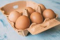Close up view of raw chicken eggs in egg box on white wooden background Royalty Free Stock Photo
