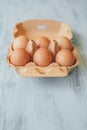 Close up view of raw chicken eggs in egg box on white wooden table. Royalty Free Stock Photo