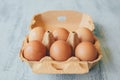 Close up view of raw chicken eggs in egg box on white wooden table. Royalty Free Stock Photo