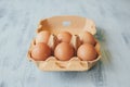 Close up view of raw chicken eggs in egg box on white wooden table. Royalty Free Stock Photo