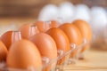 Close-up view of raw chicken eggs in egg box on wooden background Royalty Free Stock Photo