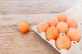 Close-up view of raw chicken eggs in egg box on wooden background. Royalty Free Stock Photo