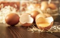 Close-up view of raw chicken eggs on wooden background. Fresh farm egg. Eggs in carton box. Broken egg with yolk. Royalty Free Stock Photo