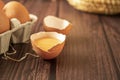 Close-up view of raw chicken eggs on wooden background. Fresh farm egg. Eggs in carton box. Broken egg with yolk. Royalty Free Stock Photo