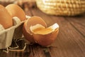 Close-up view of raw chicken eggs on wooden background. Fresh farm egg. Eggs in carton box. Broken egg with yolk Royalty Free Stock Photo