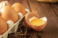 Close-up view of raw chicken eggs on wooden background. Fresh farm egg. Eggs in carton box. Broken egg with yolk. Royalty Free Stock Photo