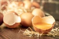 Close-up view of raw chicken eggs on wooden background. Fresh farm egg. Eggs in carton box. Broken egg with yolk. Royalty Free Stock Photo