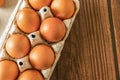 Close-up view of raw chicken eggs on wooden background. Fresh farm egg. eggs in carton box. Royalty Free Stock Photo