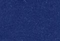 Close up view of recycled dark blue paper background with inclusions of natural fiber particles.