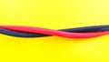 Close up of red and black electric cables isolated on yellow background Royalty Free Stock Photo