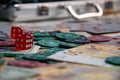 A close-up view of red dice, poker chips, and Euro banknotes scattered on a table Royalty Free Stock Photo