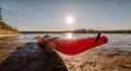 Close up view of red kayak at wet river coastline, stony slope, sunny summer day, outdoor sport activity. Umea river delta, Royalty Free Stock Photo