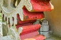 Close-up view of the red painted gears of a large mechanical machine