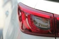 Close up view of red rear tail light of white car Royalty Free Stock Photo