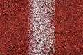 Close up view at red rubber running line with vertical white stripe in the middle, background Royalty Free Stock Photo