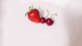 Close-up view of red strawberry and two wet sweet cherries on a white background. Design concept Royalty Free Stock Photo