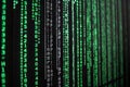 A close-up view reveals vertical lines of green binary code cascading down a dark background Royalty Free Stock Photo