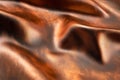 A close-up view of rich copper-toned leather showcasing its smooth, glossy surface with subtle color and texture variations Royalty Free Stock Photo