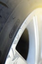 rim protection feature at the sidewall of a high perfomance car tire mounted on a scraped aluminum rim in bright sunny light