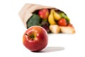 close-up view of ripe red apple and full grocery bag