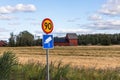 Close up view of road signs on yellow field and blue sky with white couds backgrounds.
