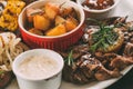 close-up view of roasted potatoes, grilled vegetables and meat with sauces Royalty Free Stock Photo