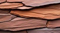 A close-up view of a rock wall composed of irregularly shaped, flat, reddish-brown stones. Royalty Free Stock Photo