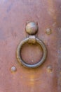 Close-up view of rusty knocker and rivets on a rusty metal door. The texture of metal and rust is visible Royalty Free Stock Photo