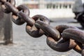 Close up view of rusty metal chain links on a blurred square at background Royalty Free Stock Photo