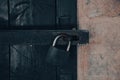 Close up view of a rusty padlock on weathered vintage wooden door with an old castle stone wall. Royalty Free Stock Photo