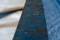 A close-up view of the rusty railing. The metal product is covered with rust. The destruction of the old bridge