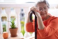 Close-up view of senior melancholy woman suffering from back pain sitting with her hands resting on the cane Royalty Free Stock Photo