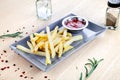 Close up view on served French fries with ketchup on white table. Royalty Free Stock Photo