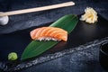 Close up view on served Nigiri with salmon on dark plate on dark background with copy space. Delicious salmon Nigiri Sushi. Royalty Free Stock Photo