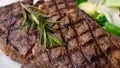 Close up view on serving of marinated grilled rib eye steak with baked potatoes and vegetables Royalty Free Stock Photo