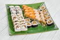 Close up view on set of assorted roll and sushi on green plate isolated on white wooden background. Sushi with salmon, eel. Royalty Free Stock Photo