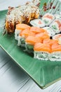 Close up view on set of assorted roll and sushi on green plate isolated on white wooden background. Sushi with salmon, eel. Royalty Free Stock Photo