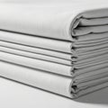 Neatly stacked light gray fabric sheets showing texture and fold detail isolated on white background Royalty Free Stock Photo
